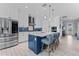 Modern kitchen featuring white cabinets, a blue island with seating, and stainless steel appliances at 4583 Emprise Way, Land O Lakes, FL 34638