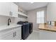 Modern laundry room with sleek cabinets, wood countertop, and state-of-the-art washer and dryer appliances at 4583 Emprise Way, Land O Lakes, FL 34638