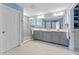 Main bathroom featuring dual sinks, gray vanities, a glass-enclosed shower, and tile flooring at 4583 Emprise Way, Land O Lakes, FL 34638