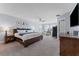 Spacious main bedroom with a wooden bed, soft carpeting, and an abundance of natural light at 4583 Emprise Way, Land O Lakes, FL 34638