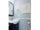 This updated bathroom features a new vanity, sink, and framed flamingo wall art at 5242 Beach Se Dr, St Petersburg, FL 33705