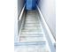 Interior staircase featuring tile steps, white railings, and neutral walls leading to the next level at 5242 Beach Se Dr, St Petersburg, FL 33705
