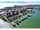 Aerial view of waterfront condos featuring boat docks and beautiful landscaping with easy access to open water at 5301 Gulf Blvd # B508, St Pete Beach, FL 33706
