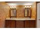 Bathroom with a double vanity featuring granite countertops and decorative mirrors at 5301 Gulf Blvd # B508, St Pete Beach, FL 33706