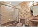 Bathroom boasting decorative wall texture, vanity sink, toilet, and shower with glass doors at 5301 Gulf Blvd # B508, St Pete Beach, FL 33706