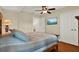 Cozy bedroom featuring a ceiling fan, wooden floors, and a TV mounted on the wall at 5301 Gulf Blvd # B508, St Pete Beach, FL 33706