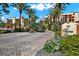 Welcoming entrance to waterfront condos with brick pavers, palm trees, and lush landscaping at 5301 Gulf Blvd # B508, St Pete Beach, FL 33706