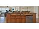 Granite counter tops accent the dark wood cabinetry and stainless appliances in this open concept kitchen with sink at 5301 Gulf Blvd # B508, St Pete Beach, FL 33706