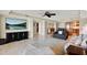 Bright living room featuring tile flooring, kitchen access, and an entertainment center with a nature-themed television at 5301 Gulf Blvd # B508, St Pete Beach, FL 33706