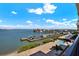 Scenic waterfront with boat docks, palm trees, and a glimpse of a pool, under a sunny sky at 5301 Gulf Blvd # B508, St Pete Beach, FL 33706