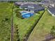 Aerial view of fenced yard featuring grass, landscaping, pool, and basketball court at 5409 Del Coronado Dr, Apollo Beach, FL 33572