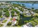 Beautiful aerial view of homes, tranquil pond with scenic water views, and lush landscaping in a serene setting at 5785 Bay Pines Lakes Blvd, St Petersburg, FL 33708