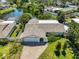 Aerial view of charming home with well-maintained landscaping, private driveway, and serene waterfront backyard at 5785 Bay Pines Lakes Blvd, St Petersburg, FL 33708