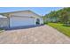 Wide brick-paved driveway leading to a well-kept single-story home with an attached two-car garage at 5785 Bay Pines Lakes Blvd, St Petersburg, FL 33708