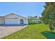 Charming single-story home featuring a well-maintained lawn, arched entryway and a brick-paved driveway at 5785 Bay Pines Lakes Blvd, St Petersburg, FL 33708