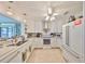 Updated kitchen features white cabinetry, modern appliances, and decorative pendant lights, perfect for entertaining at 5785 Bay Pines Lakes Blvd, St Petersburg, FL 33708