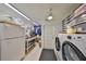Functional laundry room with washer, dryer, shelving, and storage options at 5785 Bay Pines Lakes Blvd, St Petersburg, FL 33708