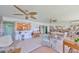 Bright living space with ceiling fans, tile floors, wicker furniture, and opening to adjacent kitchen at 5785 Bay Pines Lakes Blvd, St Petersburg, FL 33708