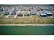 Aerial view of three homes with fenced yards, backing to green space and a waterfront view at 588 Olive Conch St, Ruskin, FL 33570