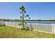 Beautiful lake view from the backyard, enhanced by a classic white picket fence at 588 Olive Conch St, Ruskin, FL 33570