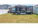 Backyard featuring a screened-in patio with stylish seating and a relaxing hot tub at 588 Olive Conch St, Ruskin, FL 33570