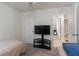 Bedroom featuring twin beds, a ceiling fan, and a view into an adjoining bathroom with tiled floors at 588 Olive Conch St, Ruskin, FL 33570