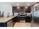 Modern kitchen with stainless appliances, granite countertops, and dark wood cabinets at 588 Olive Conch St, Ruskin, FL 33570