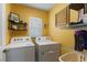 Well-lit laundry room featuring modern appliances, organized shelving, and ample space at 588 Olive Conch St, Ruskin, FL 33570