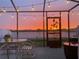 Relaxing screened patio featuring string lights and a picturesque sunset lake view at 588 Olive Conch St, Ruskin, FL 33570