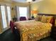 Bedroom featuring floral bedding, ceiling fan and access to a small outdoor patio at 5920 30Th S Ct, St Petersburg, FL 33712