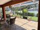 Enclosed patio with tile floor, cozy hanging chair, and view of the lush green backyard at 5920 30Th S Ct, St Petersburg, FL 33712
