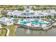 Aerial view of the Del Webb community clubhouse and pool with palm trees and lake views at 5981 Shorebird Br, Land O Lakes, FL 34638