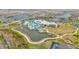 Aerial view of the Del Webb community clubhouse, pool, tennis courts, and surrounding homes and lakes at 5981 Shorebird Br, Land O Lakes, FL 34638