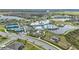 Aerial view of the Del Webb community clubhouse, pool, tennis courts, and surrounding homes and lakes at 5981 Shorebird Br, Land O Lakes, FL 34638