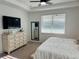 Bedroom featuring light wood furniture, a ceiling fan, a large window and a flat screen television at 5981 Shorebird Br, Land O Lakes, FL 34638
