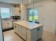White kitchen island with a breakfast bar, stainless steel appliances, and quartz countertops at 5981 Shorebird Br, Land O Lakes, FL 34638