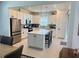 A bright white kitchen includes an island with bar seating, stainless steel appliances, and pendant lighting at 5981 Shorebird Br, Land O Lakes, FL 34638