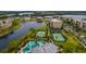Aerial view showcasing the community pool, tennis courts, and condo buildings set among lush landscaping at 7040 Key Haven Rd # 601, Seminole, FL 33777