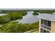 Aerial view showcasing the condo situated near a tranquil water body, lush vegetation, and a walking path at 7040 Key Haven Rd # 601, Seminole, FL 33777