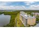 A beautiful aerial view of condo buildings near a green area, a lake, and a walking trail on a sunny day at 7040 Key Haven Rd # 601, Seminole, FL 33777
