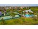 Aerial view of community featuring tennis courts, a pool, lush landscaping, and condo buildings at 7040 Key Haven Rd # 601, Seminole, FL 33777