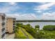 Scenic aerial shot shows exterior of a tan condominium near green foliage, a sidewalk, and tranquil waterways at 7040 Key Haven Rd # 601, Seminole, FL 33777