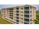 Close-up exterior view of a condominium building featuring enclosed patios, multiple windows, and metal roof at 7040 Key Haven Rd # 601, Seminole, FL 33777