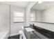 Modern bathroom with white tile, dark stone countertop and black trim at 7327 Jasmine Blvd, Port Richey, FL 34668