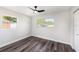 Bright bedroom featuring new floors, two bright windows, and a modern ceiling fan at 7327 Jasmine Blvd, Port Richey, FL 34668