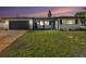 Attractive home with a dark garage door, contrasting trim, and well-kept lawn at sunset at 7327 Jasmine Blvd, Port Richey, FL 34668