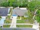 An aerial view showcases mature trees, a two-car garage, and an expansive lawn with manicured landscaping at 7414 Mint Julep Dr, Riverview, FL 33578