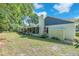 Secluded backyard featuring a covered porch, mature trees, and lush, tropical landscaping at 7414 Mint Julep Dr, Riverview, FL 33578