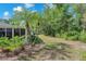A tranquil backyard featuring tropical trees and landscaping, framed with brick edging at 7414 Mint Julep Dr, Riverview, FL 33578