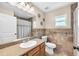 Tiled bathroom featuring a vanity, toilet, decorative wall art, and a shower with a patterned curtain at 7414 Mint Julep Dr, Riverview, FL 33578